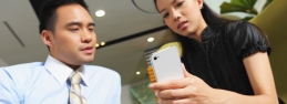 two people look at a mobile phone